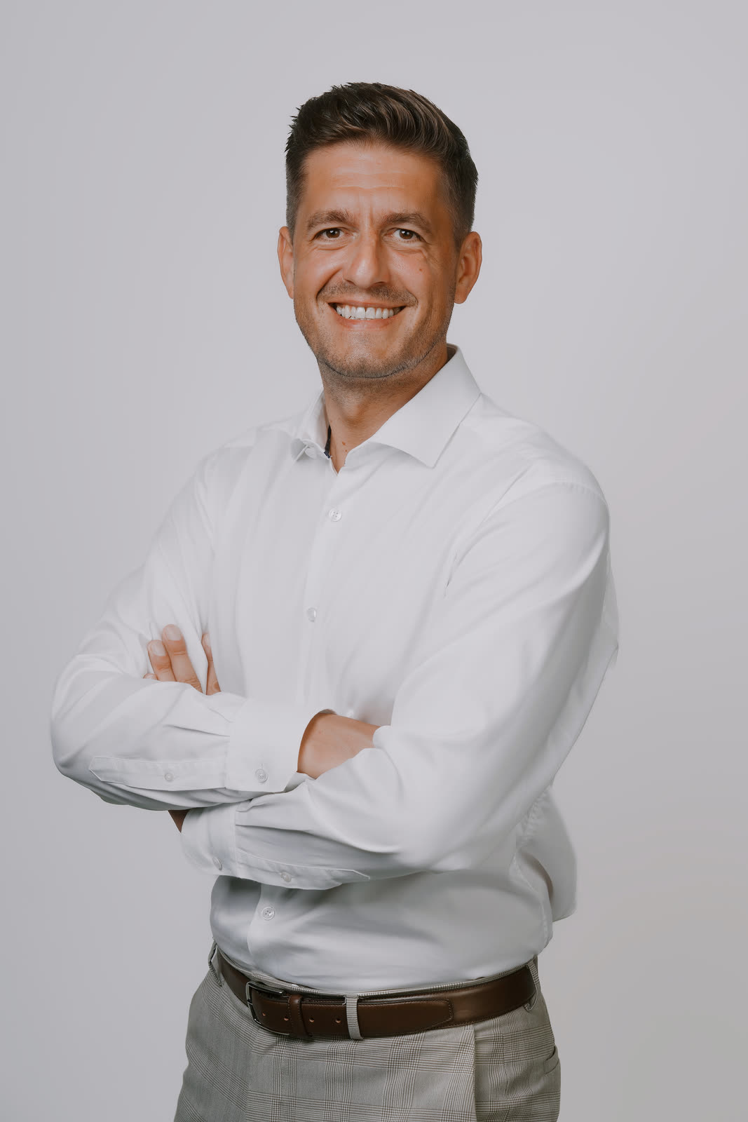Roman Krištofík v bielej košeli s prekríženými rukami
